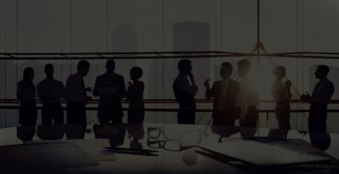 A group of businesspeople are silhouetted against a downtown window setting with a dark gray overlay