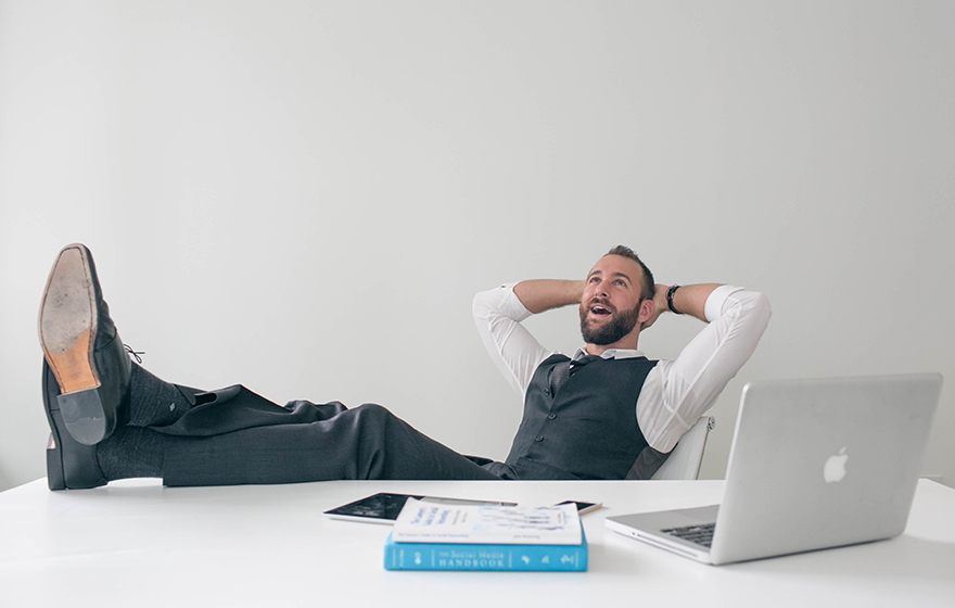 Relaxed businessman sits with his feet up on the desk
