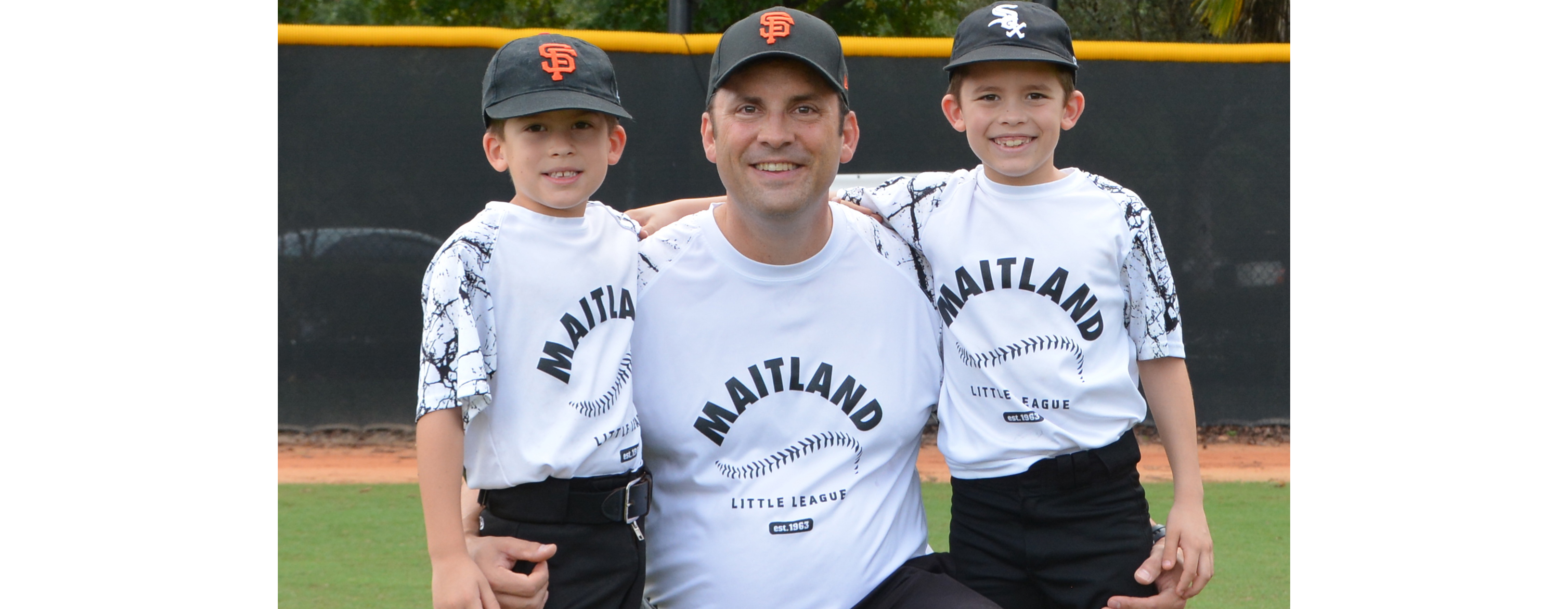 Judge Willis is pictured on the field with two young baseball players