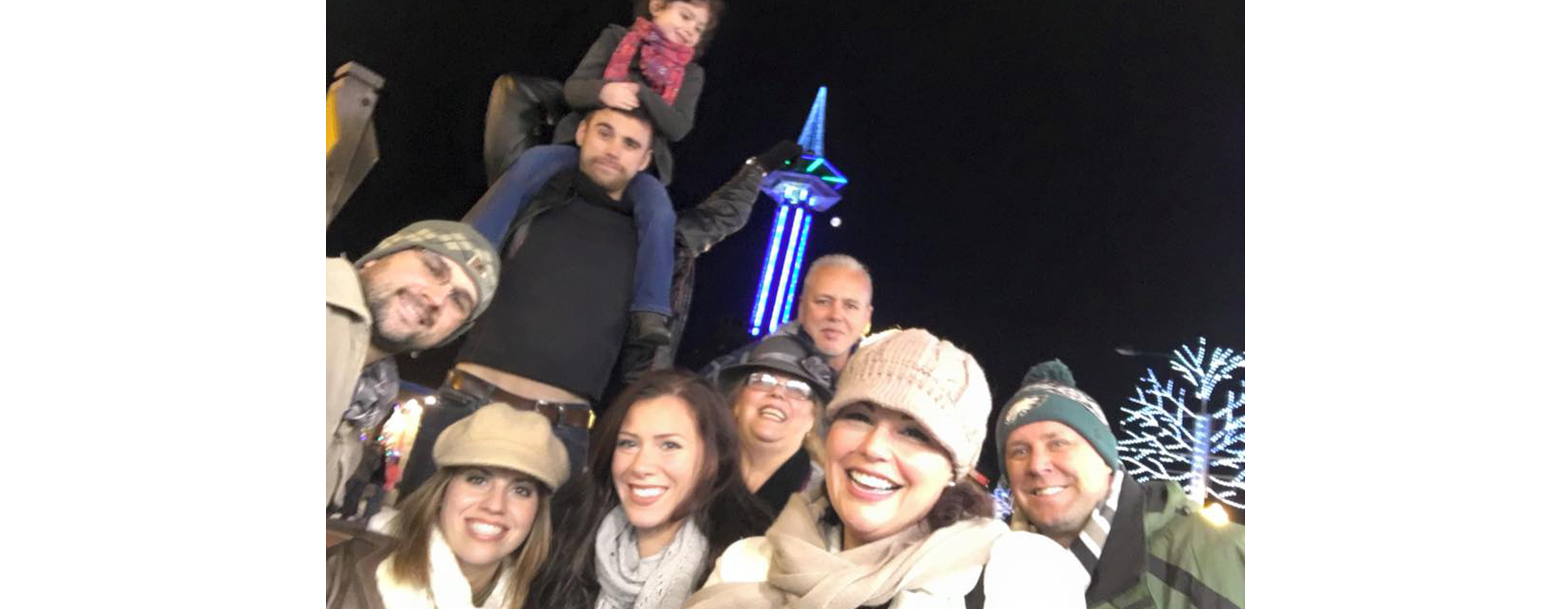 Michelle Suarez is pictured with a group of people outdoors at night in a chilly downtown setting