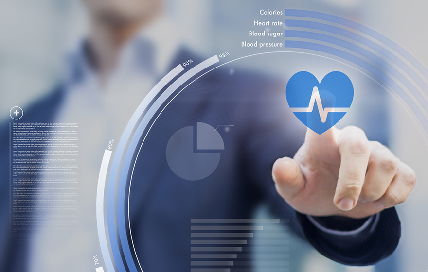 Businessman in blue suit is blurred in background, reaching out and touching a pulsing heart graphic on a screen