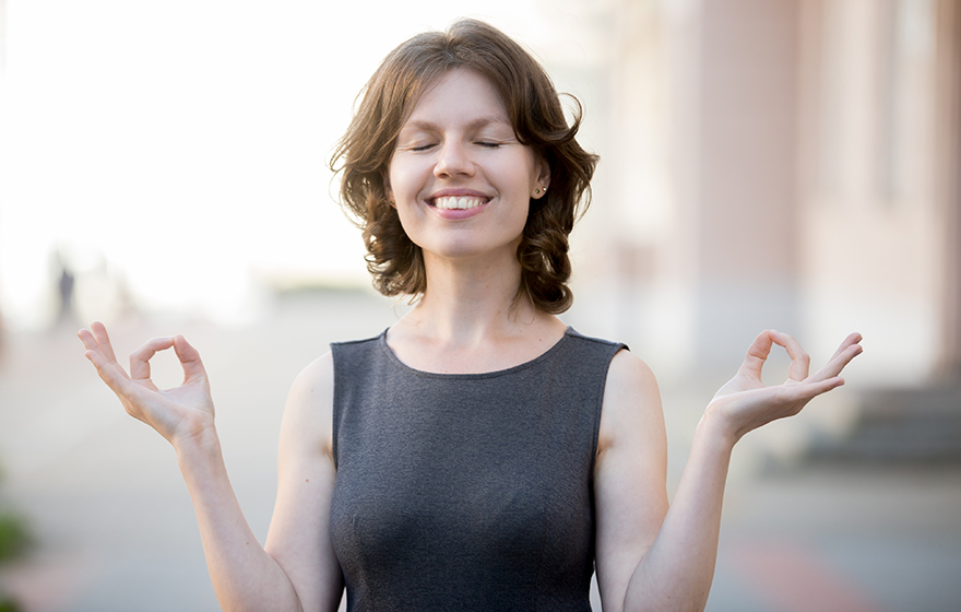 Happy middle aged Caucasian woman stands outside with eyes closed, enjoying life