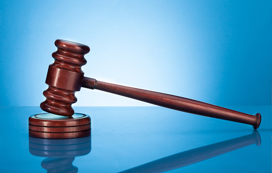 Brown gavel resting on a blue background