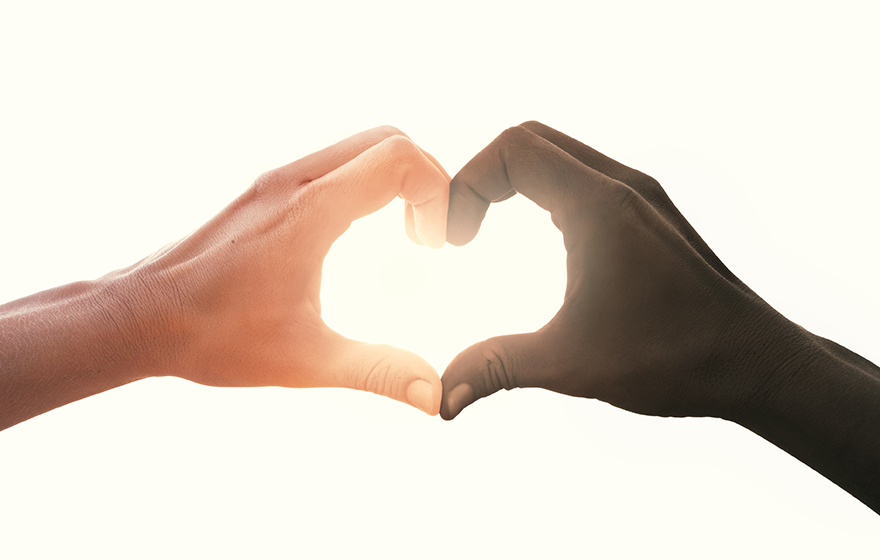 Interracial couple making a heart shaped hand gesture