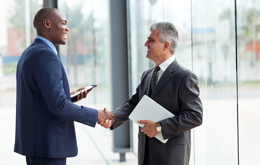 Young African American lawyer shaking hands with mature Latino lawyer
