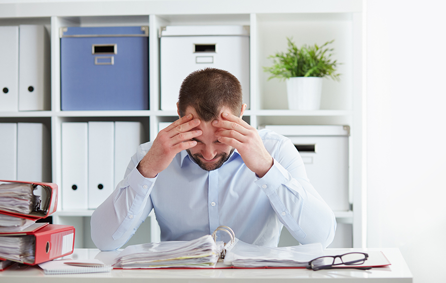 Young business man under stress with headache and migraine
