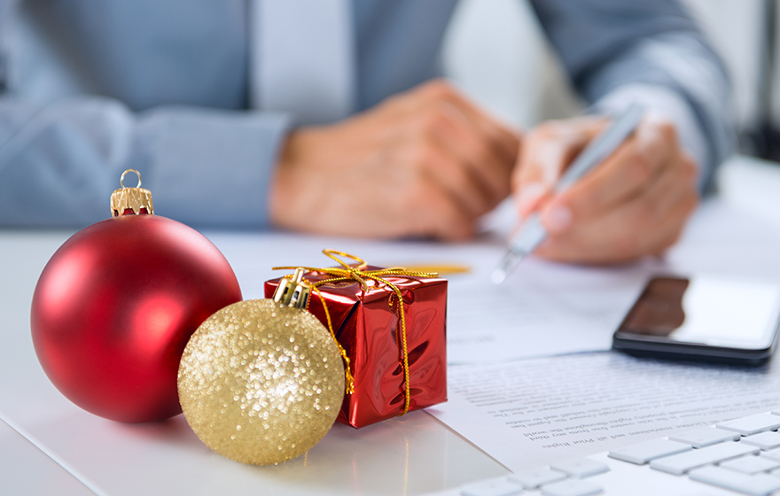 Christmas Ornament In Front Of Businessman Working At Desk