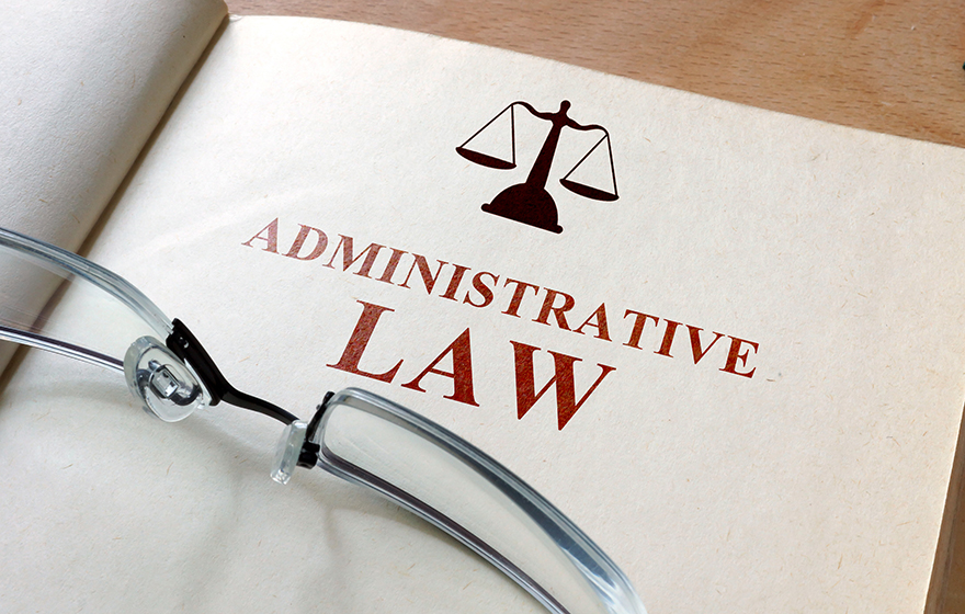 Code of administrative law on a wooden table with glasses on top of the document