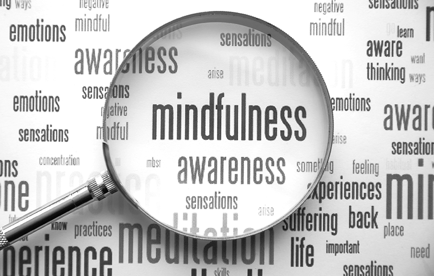 Mindfulness word bubble with magnifying glass laid over top of it