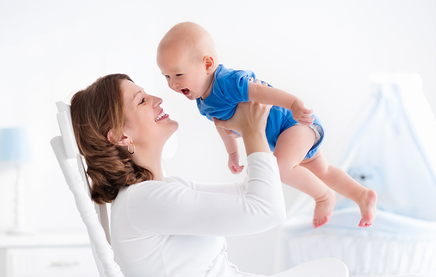 Cute young mother with baby boy at home