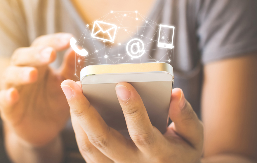 woman holding cell phone, digital icons for phone/email/internet floating around phone