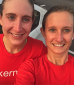 Allison Stocker and Katie Fackler headshot standing together, they are two Caucasian women with their long hair pulled back. They are wearing red tops.