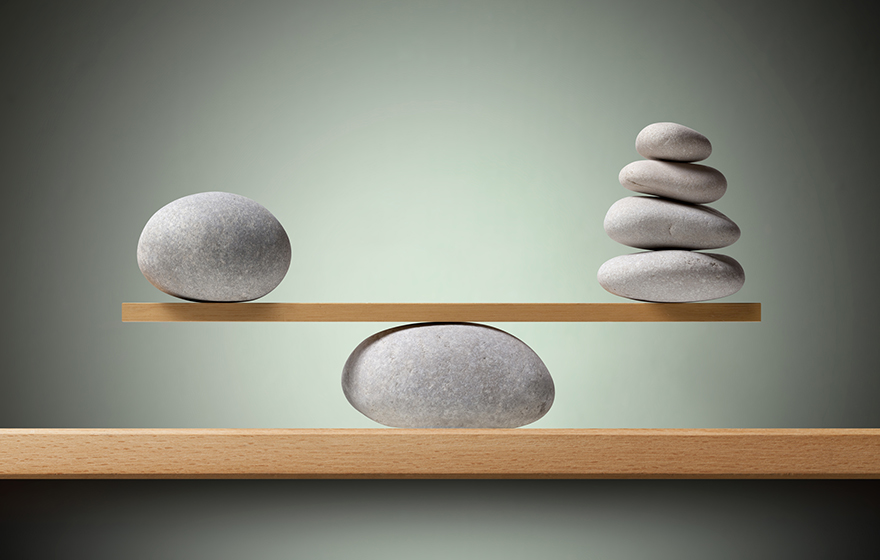 Balancing stones on the shelf sitting on top of another stone with a green background