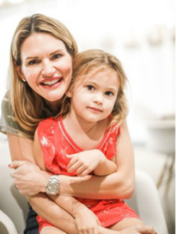 Deborah Baker-Egozi photo Deborah Baker-Egozi a smiling Caucasian woman with a young girl with light brown hair sitting in her lap