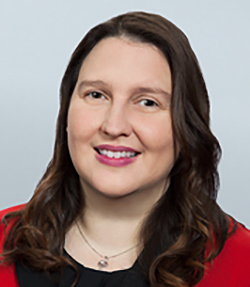 Mandi Clay headshot of a Caucasian woman in a black and red blouse with medium length curled brown hair.