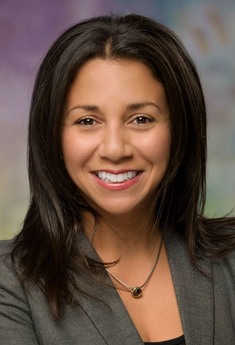 Michelle Bedoya Barnett mug Michelle Bedoya Barnett headshot of a happy Latina woman with medium length dark hair. She has brown eyes and is wearing a grey top.