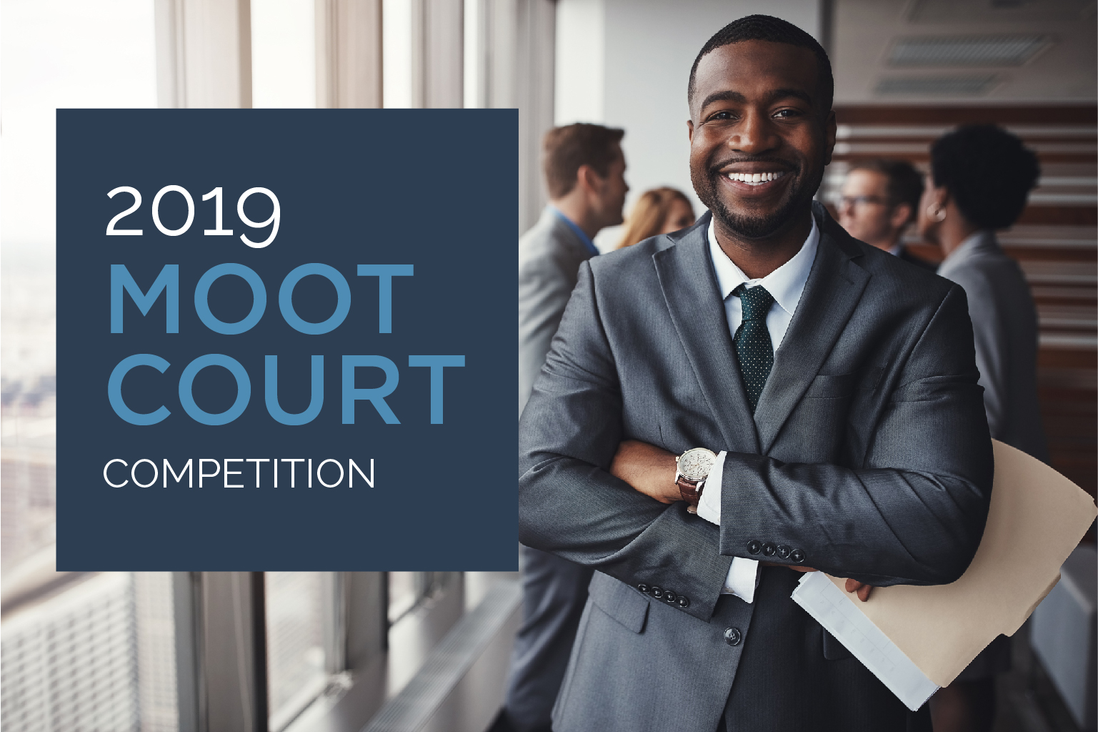 FLAYLD 2019 Moot Court Competition with young male lawyer in grey suit smiling at camera in office