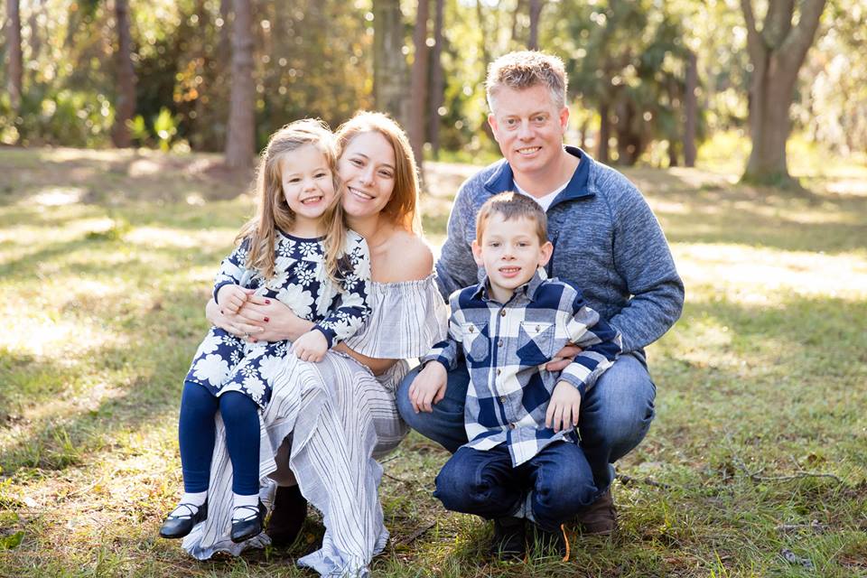 family Traci Koster a young Caucasian woman with her Caucasian husband and two Caucasian children, one boy and one girl. The girl is seated in her lap.