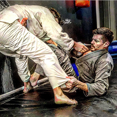 JeremyScott_2 Jeremy Scott a Caucasian man in martial arts uniform on ground doing a martial arts move with another man standing over him