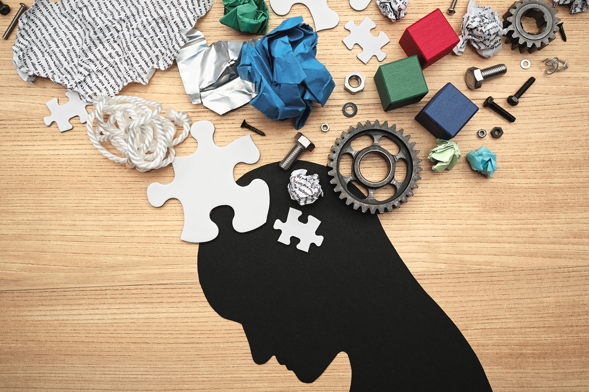 Various parts and head silhouette on wood background.