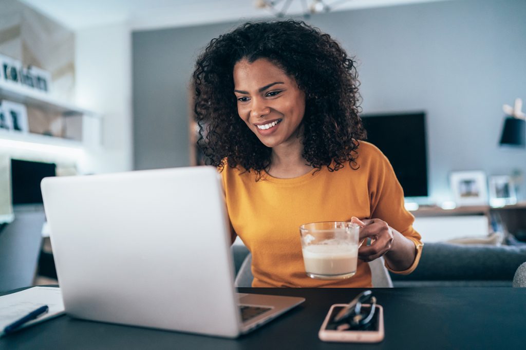 Young modern woman working from home, using laptop in quarantine