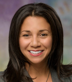 Michelle Bedoya Barnett headshot of a happy Latina woman with medium length dark hair. She has brown eyes and is wearing a grey top.