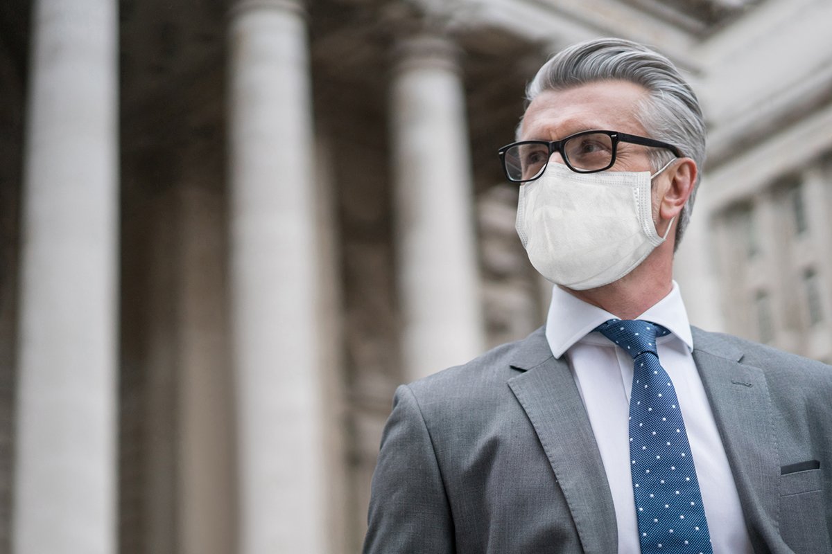 Business man on the street wearing a facemask to avoid COVID-19